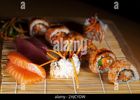 Eine gemischte Platte mit Sushi und Sashimi. Die Gerichte stammen aus Japan und werden mit dünn geschnittenem rohem Fisch zubereitet. Stockfoto