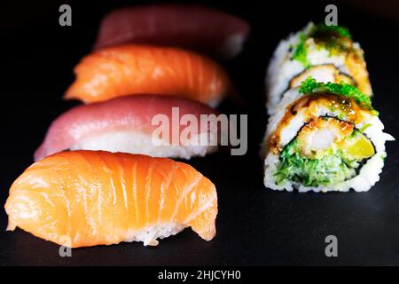 Eine Platte mit Thunfisch und Lachs Nigiri serviert mit Uramaki. Arten von Sushi, das Gericht stammt aus Japan. Stockfoto