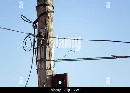 Alte Telefonkabel-Installation auf einem Holzmast Stockfoto
