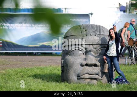 Hay Festival, eine Dame macht am 26th. Mai 2018 ein Selfie mit einer riesigen Skulptur eines mexikanischen Haed in Hay-on-Wye, Powys, Wales. Stockfoto