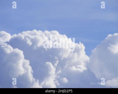 Cumulus Wolken auf einem blauen sonnigen Himmel Hintergrund. Wolkenlandschaft mit sanfter Fokussierung und weißen Wolken bis hin zu grauem Farbton. Himmlische Abstraktion. Stockfoto