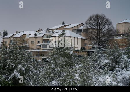 Der Morgen dämmert über den schneebedeckten Dächern und Bäumen von Mevasseret Zion, Israel, einer Stadt im Judäa-Gebirge, in der Nähe von Jerusalem. Stockfoto