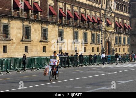 Mexiko-Stadt, Mexiko, 15. Dezember 2016: Ein Radfahrer transportiert Fracht um den Nationalpalast (spanisch: Palacio Nacional), der Sitz der Föderation ist Stockfoto