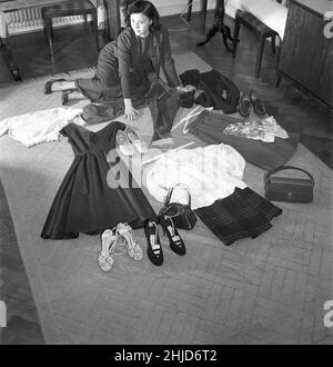 1950s Mädchen. Schauspielerin Harriet Andersson auf dem Boden, wo auch ein Teil ihrer Garderobe zu sehen ist, ein Kleid, Röcke in verschiedenen Längen, Schuhe und Jacken im typischen 1950s Fashion Style. Schweden 1952. Kristoffersson Ref. BH81-5 Stockfoto