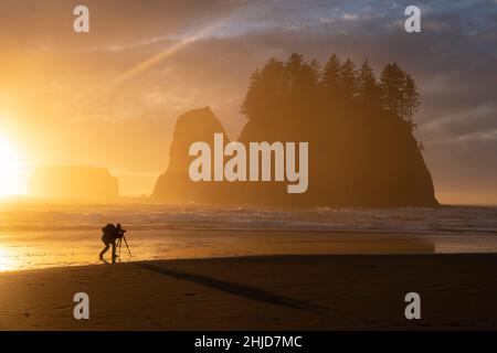 Ein Fotograf fängt einen dramatischen Sonnenuntergang am Second Beach des Olympic National Park auf der Olympic Peninsula in Washington ein. Stockfoto