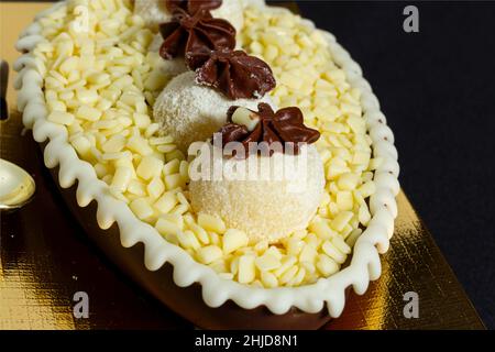 Brasilianisches osterei gefüllt mit weißer granulierter Schokolade und Creme, schmeckte mit einem Löffel. Ostertradition in Brasilien Stockfoto