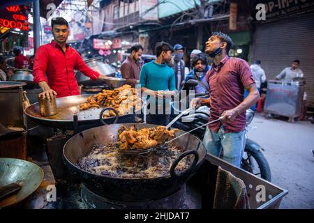 Neu-Delhi, Indien. 28th Januar 2022. Ein Mann sah, wie er knusprig gebratenes Huhn im Haji Mohd Hussain-Laden im Matia Mahal Market, Jama Masjid, Alt-Delhi, herstellte.Märkte und Einkaufszentren in der Hauptstadt wurden in voller Kapazität eröffnet, nachdem die Regierung von Delhi beschlossen hatte, die Sperrstunde am Wochenende und die ungerade Regel für Geschäfte aufzuheben. Kredit: SOPA Images Limited/Alamy Live Nachrichten Stockfoto