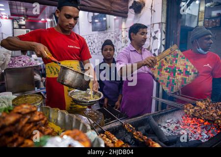 Neu-Delhi, Indien. 28th Januar 2022. Ein Mann sah, wie er im Aslam-Hühnerladen in Matia Mahal, Jama Masjid, Alt-Delhi, gebratenes Butterhuhn herstellte.Märkte und Einkaufszentren in der Hauptstadt wurden in voller Kapazität eröffnet, nachdem die Regierung von Delhi beschlossen hatte, die Sperrstunde am Wochenende und die ungerade Regel für Geschäfte aufzuheben. Kredit: SOPA Images Limited/Alamy Live Nachrichten Stockfoto