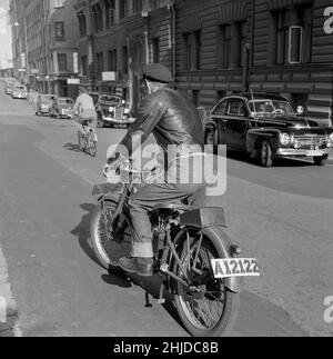 Motorradfahrer in der 1950s. Ein junger Mann auf seinem Motorrad, der den Kick benutzt, um den Motor anzulassen. Schweden 1951 Stockfoto