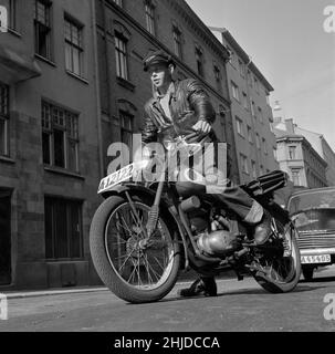 Motorradfahrer in der 1950s. Ein junger Mann auf seinem Motorrad, der den Kick benutzt, um den Motor anzulassen. Schweden 1951 Stockfoto