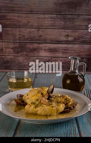 Dogfish mit Muscheln und Garnelen, auf einem Holztisch und Weißwein. Stockfoto