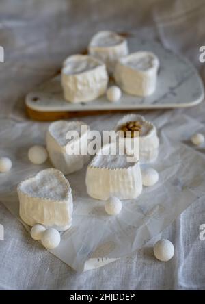 Herzförmiger Käse mit weißer Schimmelpilze auf Geschenkpapier. Eigenproduktion, Naturprodukte. Stockfoto