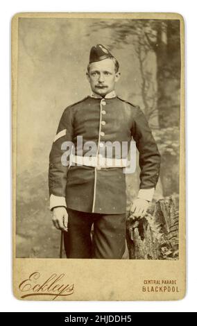 Original viktorianische Carte de viste (CDV) des Soldaten in zeremonieller Uniform im East Lancashire Regiment, (ein Infanterie-Regiment) trägt eine Felddienstmütze mit Abzeichen, hält einen Hakenstock, Manschettengeflecht, die 2 Chevron auf dem Ärmel bezeichnet einen Korporal, in den meisten Einheiten befehligt ein Korporal einen Abschnitt. Aus dem Studio von Eckleys, Blackpool, Lancashire, Großbritannien um 1881. Stockfoto