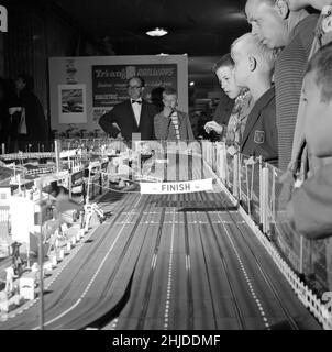 Spielzeug in der 1960s. Ein Junge fasziniert von einer Miniatur-Rennstrecke von Scalextric. Man konnte Autos mit einer Fernbedienung fahren und gegeneinander antreten, da es das war, worum es im Spiel ging. Schweden 1962 Stockfoto