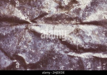 Retro-Farbbild eines alten, geknitterten Metallblechs, dunkler abstrakter Grunge-Hintergrund oder Textur. Stockfoto