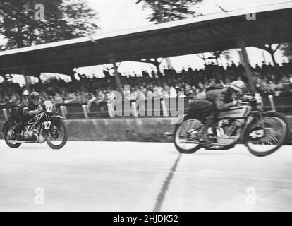 Motorrad-Rennen in der 1930s. Der Schwede Ragnar Ragge Sunnqvist gewinnt den Großen Preis von Deutschland auf Avus 1935. Mit der Nummer 45 auf seinem Husqvarna Rennmotorrad 500cc überquert er das Ziel vor dem deutschen Fahrer Gall. Stockfoto