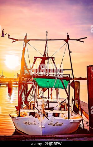 Am 31. August 2014 geht die Sonne auf einem Garnelenboot mit Holzrumpf in Bayou La Batre, Alabama, unter. Die Stadt ist bekannt als die Meeresfrüchtetropole von Alabama. Stockfoto