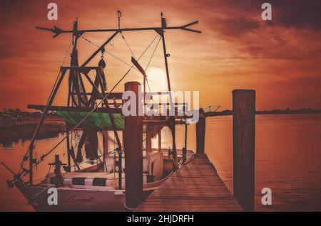 Am 31. August 2014 geht die Sonne auf einem Garnelenboot mit Holzrumpf in Bayou La Batre, Alabama, unter. Die Stadt ist bekannt als die Meeresfrüchtetropole von Alabama. Stockfoto