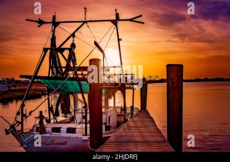 Am 31. August 2014 geht die Sonne auf einem Garnelenboot mit Holzrumpf in Bayou La Batre, Alabama, unter. Die Stadt ist bekannt als die Meeresfrüchtetropole von Alabama. Stockfoto