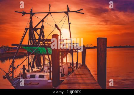 Am 31. August 2014 geht die Sonne auf einem Garnelenboot mit Holzrumpf in Bayou La Batre, Alabama, unter. Die Stadt ist bekannt als die Meeresfrüchtetropole von Alabama. Stockfoto