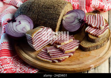 Geräucherten Speck und Fleisch mit schwarzem Brot und Zwiebeln verquälen Stockfoto