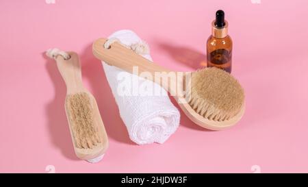 Schwarze Flaschen mit kosmetischem Öl ohne Markennamen. Natürliche Bio-Spa-Kosmetik, umweltfreundliche Bad-Accessoires. Holzbürste zur Reinigung des Gesichts und Stockfoto