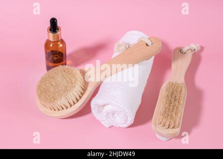 Schwarze Flaschen mit kosmetischem Öl ohne Markennamen. Natürliche Bio-Spa-Kosmetik, umweltfreundliche Bad-Accessoires. Holzbürste zur Reinigung des Gesichts und Stockfoto