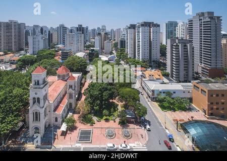 Moema-Viertel, São Paulo, Brasilien. Städtische Skyline des Viertels mit der Kirche Nossa Senhora Aparecida und der Metrostation Moema (Vordergrund) Stockfoto