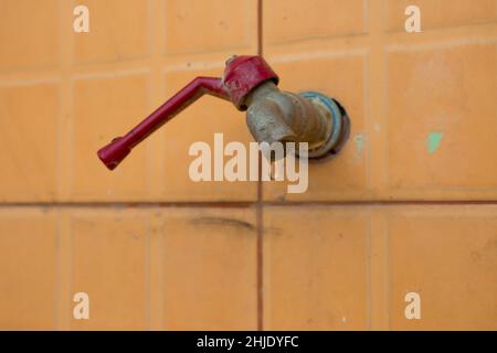 Alter Wasserhahn auf Betonwand, speichern das Wasserkonzept Stockfoto