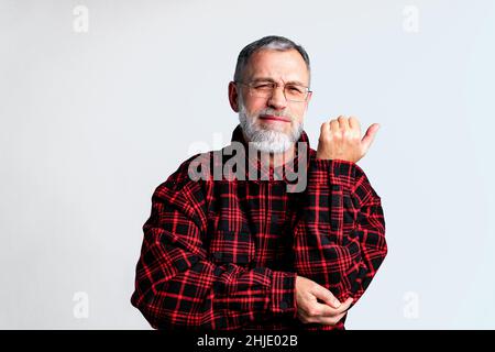 Porträt eines reifen Mannes auf grauem Hintergrund isoliert, der unter schweren Körperschmerzen leidet und die Augen schließt, um Schmerzen zu lindern Stockfoto