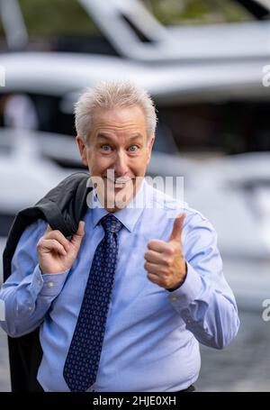 Erfolgreicher Geschäftsmann lächelt und zeigt Daumen nach oben Stockfoto