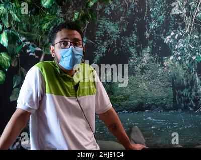 Medellin, Antioquia, Kolumbien - November 10 2021: Junger Mann mit lockigen Haaren und Brille führt einen Besuch in einem Museum Stockfoto