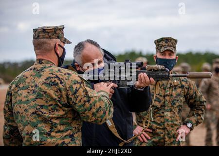 Camp Lejeune, Usa. 28th Januar 2022. Der US-Navy-Minister Carlos Del Toro zeigt, wie man ein M27 Infanterie-Automatikuhrgewehr abfeuern kann, während er am 28. Januar 2022 im Camp Lejeune, North Carolina, den Live-Schiessstand der II Marine Expeditionary Force besuchte. Kredit: LCpl. Ryan Ramsammy/US Marines/Alamy Live News Stockfoto