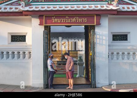 Ein Lotterieverkäufer und potenzieller Kunde stehen am Eingang zum Wat Boworniwet in Banglamphoo, Bangkok, Thailand, einem der Wahrzeichen der Stadt Stockfoto