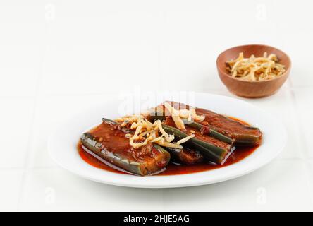 Terong Balado oder Gggplant mit Chili und Tomatensauce. Servieren auf weißem Teller White Table. Aubergine Red Curry ist indonesisches Essen, das aus Padan stammt Stockfoto