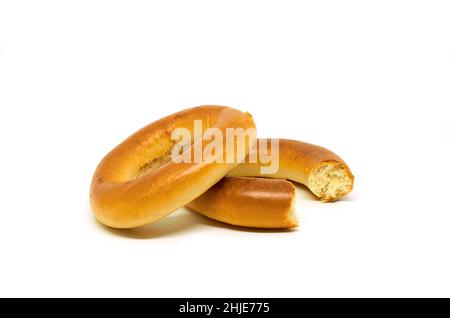 Ganze und gebissene Bagels auf weißem Hintergrund Stockfoto