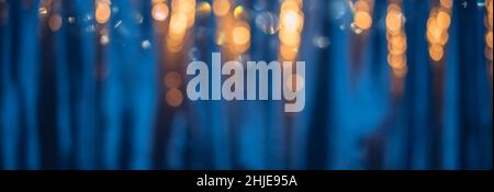 Unschärfer blauer Hintergrund mit warmen Bokeh-Lichtern Stockfoto