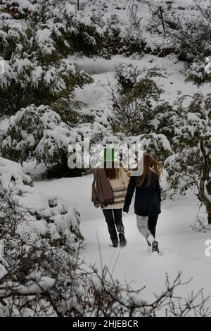 Zwei junge Frauen machen einen Spaziergang im Schnee in den Judäa-Bergen in der Nähe von Jerusalem, Israel. Stockfoto
