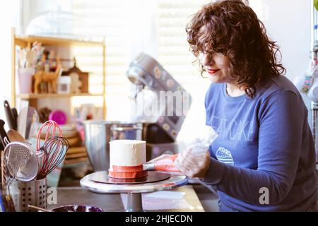Kaukasische Frau, die einen Kuchen vorbereitet. Backen zu Hause. Selektiver Fokus. Stockfoto