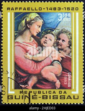 GUINEA-BISSAU - UM 1983: Eine in Guinea-Bissau gedruckte Briefmarke aus der Ausgabe '500. Birth Anniversary of Raphael' zeigt della Tenda Madonna. Stockfoto