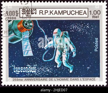KAMPUCHEA - UM 1986: Eine in Kampuchea gedruckte Briefmarke, die zum 25.. Jahrestag des ersten Mannes im All herausgegeben wurde, zeigt den Kosmonauten Alexej Leonow auf dem Weltraumspaziergang. Stockfoto