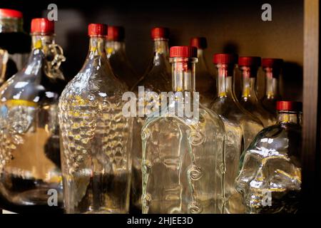 Geformte Glasflaschen auf dem Regal. Nahaufnahme Stockfoto