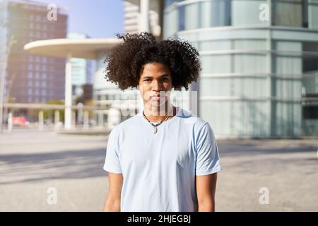 Ein junger afroamerikanischer Mann, der mit einem ernsten Gesicht auf die Kamera blickt. Stockfoto