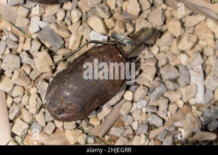 Nahaufnahme einer rostigen Granate auf dem Boden. Splittergranate Stockfoto