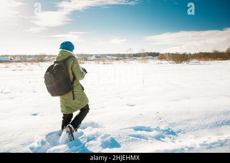 Junge Frau Tourist Lady Fotografieren Aufnahme Von Bildern Der Verschneiten Landschaft In Sonnigen Wintertag. Aktiver Lifestyle Mit Rucksack Und Kamera Stockfoto