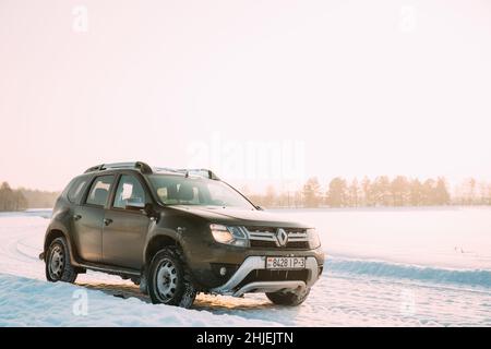 Gomel, Weißrussland. Auto Renault Duster Oder Dacia Duster Suv Geparkt Auf Winter Snowy Feld Bei Sonnenuntergang Dawn Sonnenaufgang. Stockfoto