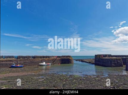 Der Haupteingang zum Johnshaven Fishing Harbour bei Low Tide an einem Summers Day an der Ostküste Schottlands. Stockfoto