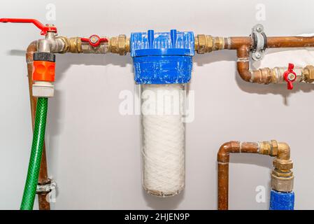 Neue 20-Mikron-Wassersaiten-Kartusche, die vor dem Hauptwassereingang im Haus platziert wird. Stockfoto