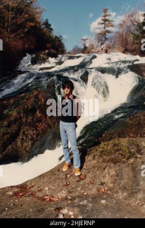 Fotograf während der Reise mit Kamera im Hintergrund. Gescannte Kopie des Archivfotos Stockfoto