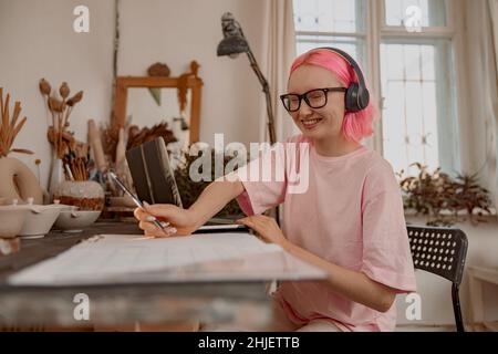 Junge und lächelnde Töpferin, die im Kunstatelie Geschäfte macht Stockfoto